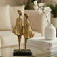 modern abstract figure sculpture in black and gold styled on a shelf