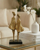 modern abstract figure sculpture in black and gold styled on a shelf