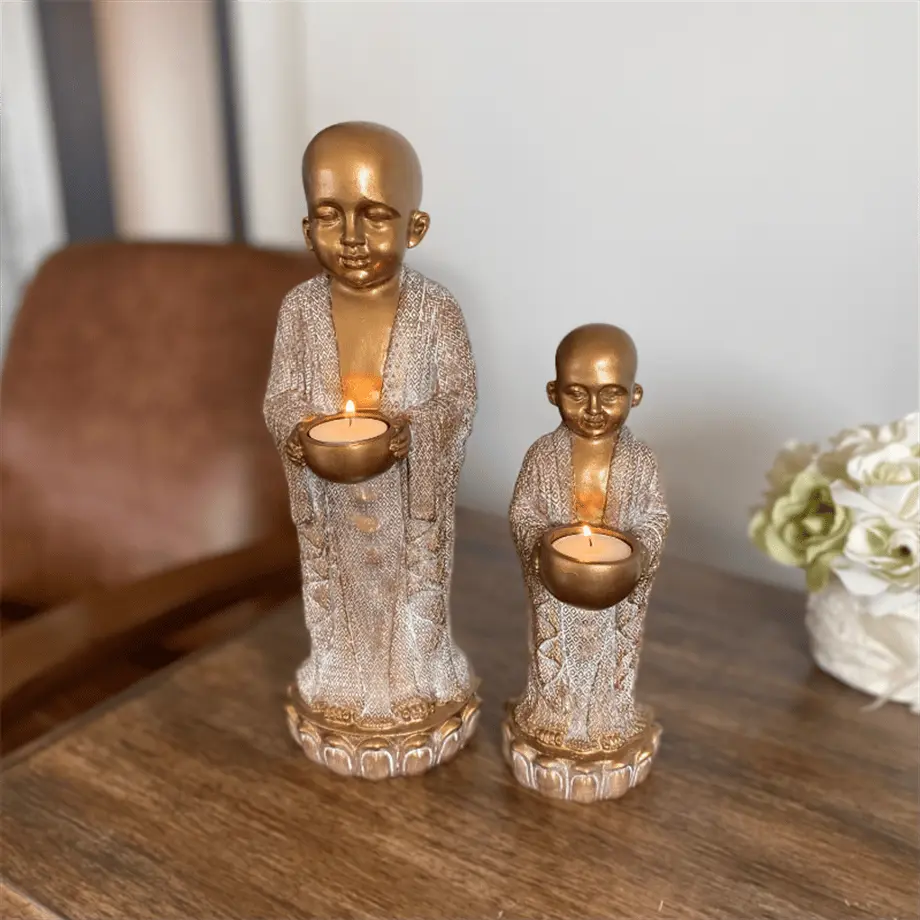 decorative buddhist monk candle holder with candlelight on a console tables