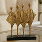 handmade black and gold abstract sculpture with four figures symbolising unity and balance