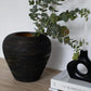 textured black and gold ceramic vase styled on a modern console table
