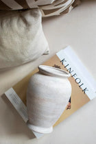 textured cream and brown ceramic vase styled on a modern console table
