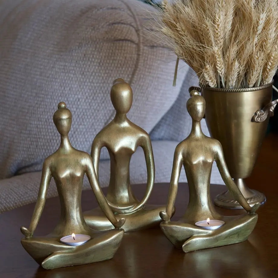 decorative gold candle holder figures styled on a console table