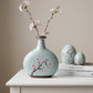 decorative green and brown ceramic vase styled on a modern console table