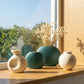 pastel green and cream ceramic vase set styled on a modern console table