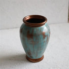sculptural turquoise ceramic vase with copper details for contemporary interiors