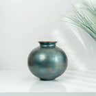 decorative petrol green ceramic cube vase styled on a modern console table