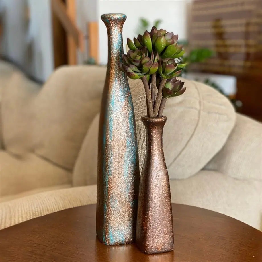 decorative petrol green ceramic vase with copper glitter details on a console table