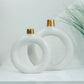 decorative white ceramic ring vase set styled on a console table