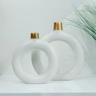 decorative white ceramic ring vase set styled on a console table
