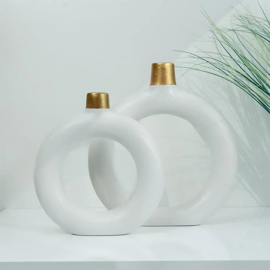 decorative white ceramic ring vase set styled on a console table
